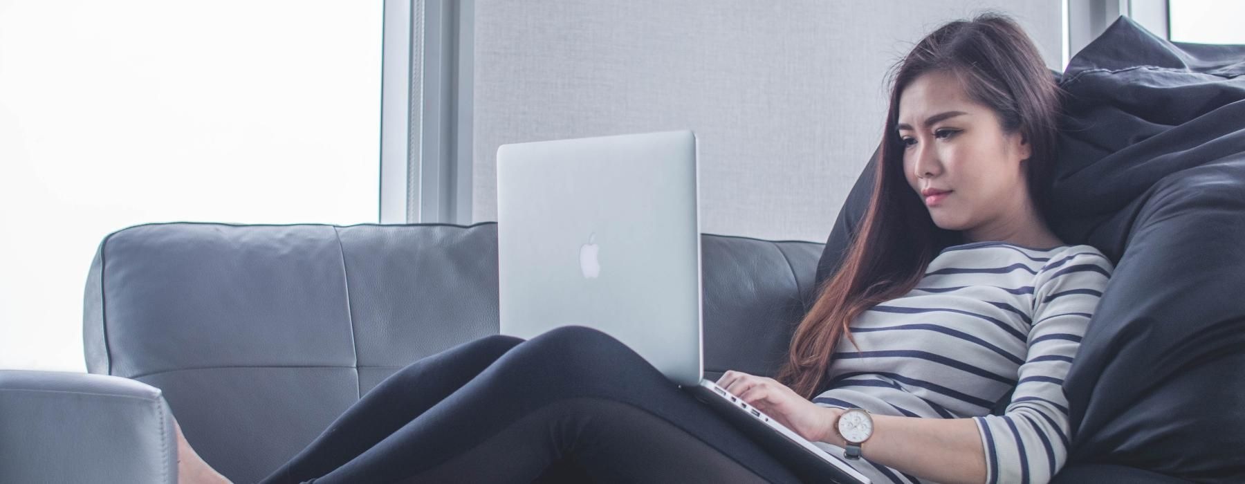 a person sitting on a couch with a laptop