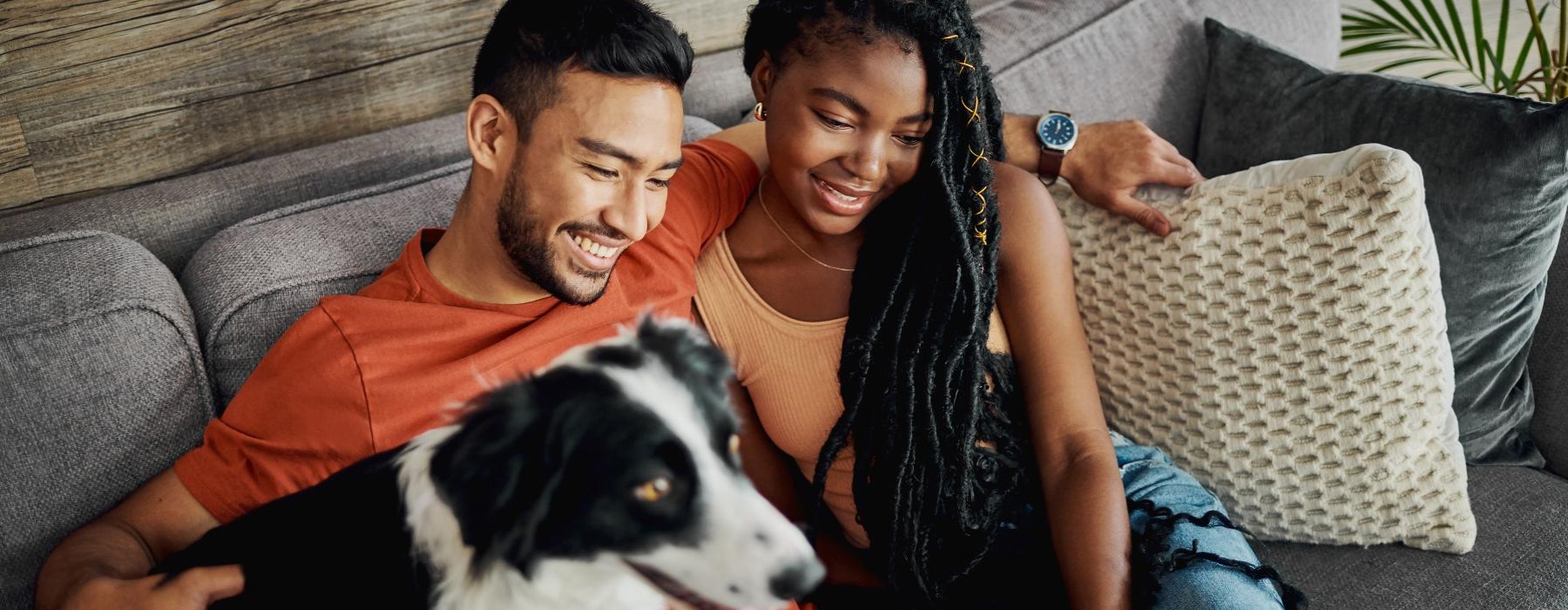 a man and woman sitting on a couch with a dog