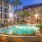a pool in a courtyard with palm trees and buildings