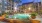a pool in a courtyard with palm trees and buildings