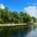 a body of water with trees and a monument in the background