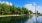 a body of water with trees and a monument in the background